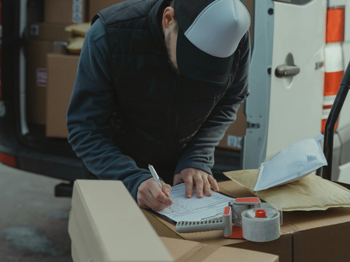 A lean startup office in San Francisco with a clean 'Postage Station' featuring organized sheets of Forever Stamps and a digital scale, replacing a bulky mailing meter.
