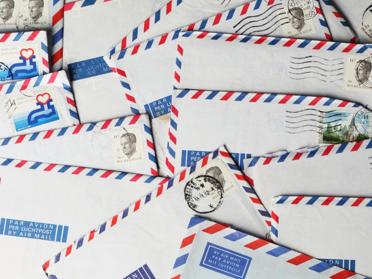 A frantic but organized wedding planner's desk in Philadelphia with a timeline calendar, stacks of returned invites, and a 'Rescue Kit' of surplus stamps.